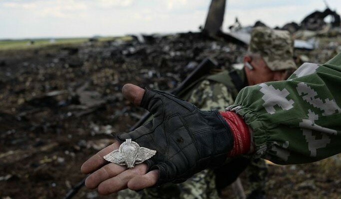 epa04257091 Pro-Russian fighters shows Ukrainian logo of paratroopers near downed Ukrainian military transport plane (IL-76) in the eastern city of Luhansk, 14 June 2014. The Ukrainian prosecutor's office confirmed early 14 June that 49 people were killed after separatists shot down an Ilyushin-76 transport plane of the Ukraine Air Force's as it was approaching an airport in Luhansk. EPA/MSTYSLAV CHERNOV