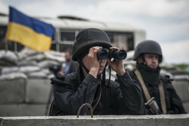 epa04192317 An Ukrainian soldier uses his binoculars at a checkpoint not far of Slaviansk, Ukraine, 05 May 2014. At least five pro-Russian activists were reported badly injured in fighting in the outskirts of the eastern Ukrainian city of Slaviansk, a rebel representative told the Interfax news agency Monday, as fighting flared anew in the troubled region. The pro-Western government in Kiev on 02 May started a fresh attempt to quash the rebellion, which it says is actively supported by Russia. Commanders say that Ukrainian army and Interior Ministry troops have fully encircled the city of more than 100,000 inhabitants. EPA/ROMAN PILIPEY